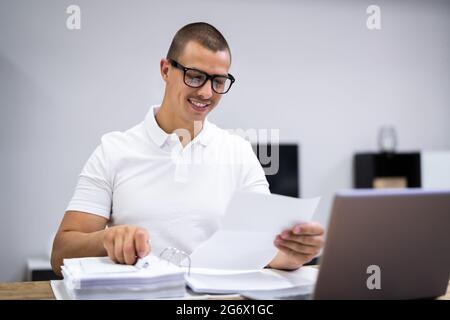 Glücklicher Junger Mann, Der Steuern Und Geldbudget Macht Stockfoto