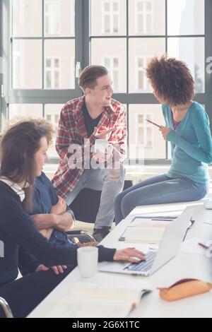 Fröhliche Studenten in eine lustige laute Gespräche während der Pause im Klassenzimmer einer modernen Universität mit internationalen Studenten Stockfoto