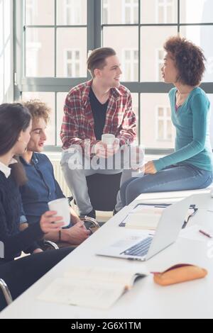 Fröhliche Studenten in eine lustige laute Gespräche während der Pause im Klassenzimmer einer modernen Universität mit internationalen Studenten Stockfoto