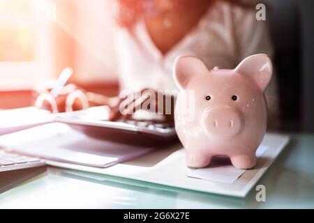 African Accounting Tax Advisor Mit Rechner Und Piggy Bank Stockfoto