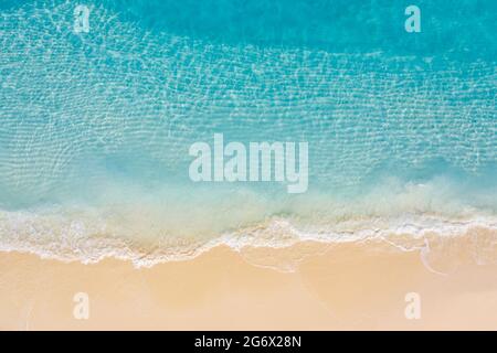 Luftaufnahme des Sandstrandes und des Ozeans mit Wellen. Entspannendes Luftbild von oben von der Drohne eines atemberaubenden wunderschönen Strandes mit türkisfarbener Meereslandschaft Stockfoto