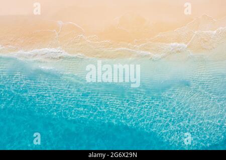Luftaufnahme des Sandstrandes und des Ozeans mit Wellen. Entspannendes Luftbild von oben von der Drohne eines atemberaubenden wunderschönen Strandes mit türkisfarbener Meereslandschaft Stockfoto
