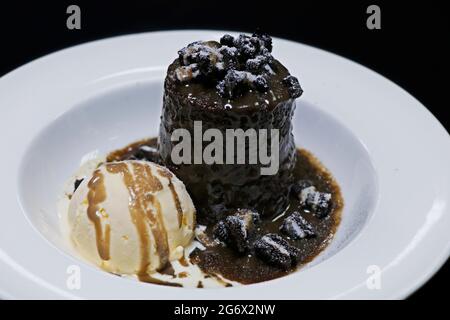 Authentischer klebriger Toffee-Pudding mit Vanilleeis und Karamellsoße Stockfoto