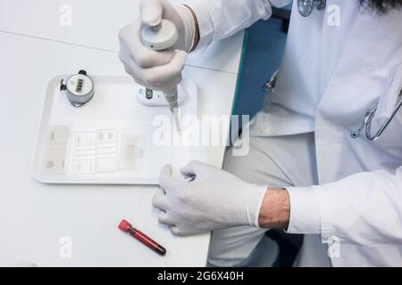 Laborantin, die Kontrolle im Labor Mikroskop-Objektträger vorbereiten Stockfoto