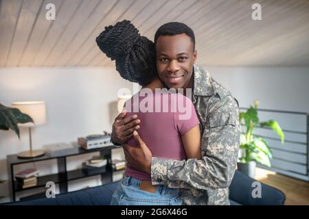 Attraktive afroamerikanische in Camouflage umarmt Frau Stockfoto