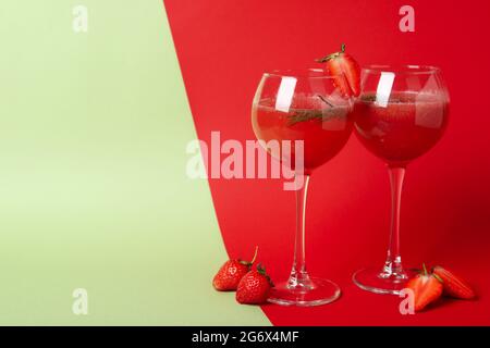 Alkoholischer Cocktail Rossini und Zutaten auf zweifarbigem Hintergrund Stockfoto