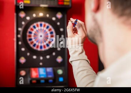 Nahaufnahme der Hand des Mannes, die auf Dartscheibe zielt Stockfoto