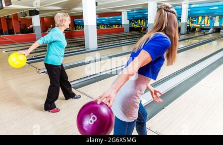 Mutter und Tochter genießen Bowling-Spiel im Club Stockfoto