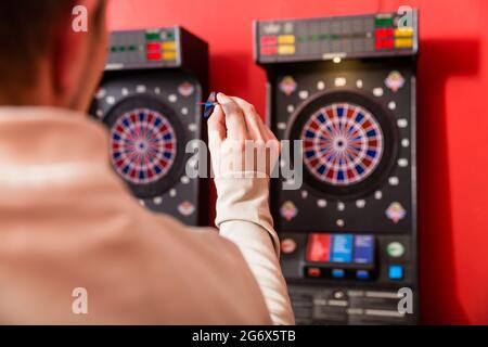 Nahaufnahme der Hand des Mannes, die auf Dartscheibe zielt Stockfoto