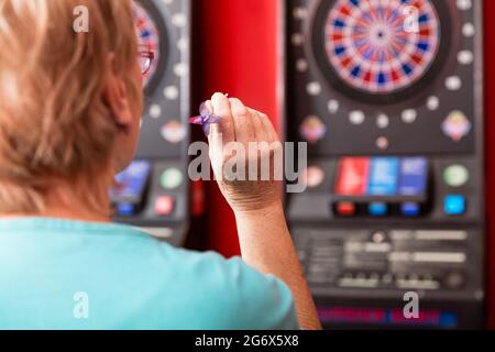 Ansicht der Rückseite eine reife Frau, die gegen die Dartscheibe Stockfoto