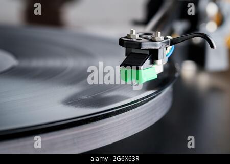 Ein Plattenspieler-Stylus wird auf eine Platte oder LP auf einem Hifi-Plattenspieler fallen. Die Nadel des Eingabestifts ist deutlich sichtbar und die Aufzeichnung dreht sich Stockfoto