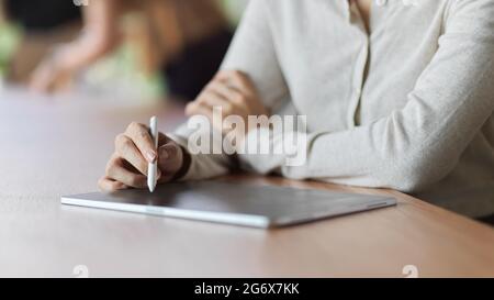 Nahaufnahme einer Frau mit Tablet mit Stylus Pen, um sich Notizen zu machen, während sie sich trifft, Frau mit Tablet mit Stylus Pen Konzept Stockfoto