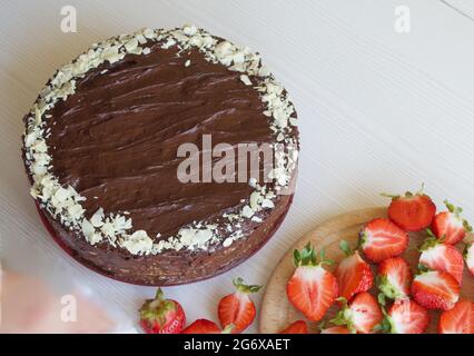 Schokoladenkuchen mit Erdnüssen und Erdbeeren. Der Prozess der Herstellung eines Kuchens. Stockfoto