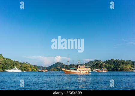 Idyllische Küste mit Segelbooten, die an einem sonnigen Sommertag auf der Insel Flores, Indonesien, an der Küste festmachen Stockfoto