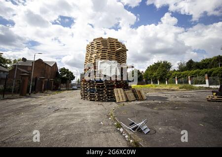 Datei-Foto vom 06/07/21 von einem umstrittenen loyalistischen Lagerfeuer, das an der Schnittstelle im Norden von Belfast errichtet wurde und den loyalen Tiger's Bay und die nationalistische New Lodge trennt. Zwei Minister von Stormont haben der Polizei in Nordirland rechtliche Schritte angedroht, weil sie nicht bei der Beseitigung eines umstrittenen loyalistischen Feuers mitgeholfen haben. Ausgabedatum: Freitag, 9. Juli 2021. Stockfoto