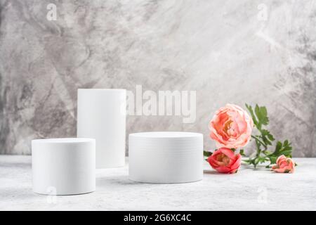 Minimaler Produktständer mit Ranunculus-Blüten. Kosmetikständer. Speicherplatz kopieren Stockfoto