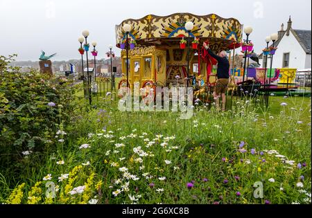 North Berwick, East Lothian, Schottland, Großbritannien. Juli 2021. UK Wetter: Neblig am Meer: Die Küstenstadt ist von haar oder Meeresnebel umgeben, mit wenigen Besuchern am Strand. Es ist warm und schwül. Im Bild: Das traditionelle Kinderkarussell bereitet sich auf die Besucher vor Stockfoto