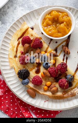 Nahaufnahme von Crepes mit Beeren und Nüssen auf dem Teller Stockfoto