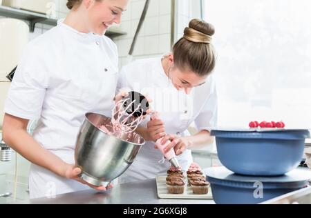 Pasty Bäcker oder Konditor, Creme auf Kuchen Stockfoto