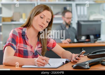 Eine Frau schreibt auf ihr Clipboard Stockfoto