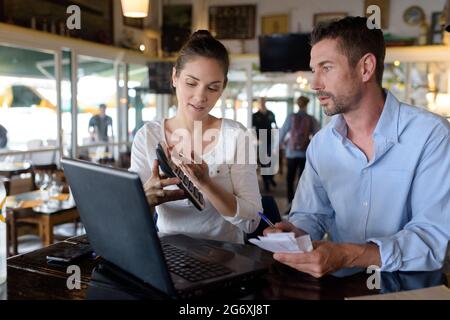 Cafe-Besitzer arbeiten über ihre Konten Stockfoto