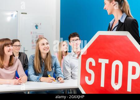 Fahrlehrer Holding theoretischen Teil der Fahrstunden mit STOP-Schild in der Hand. Stockfoto