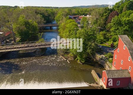 Luftaufnahme einer alten roten Mühle in Clinton, New Jersey, einer historischen Flussstadt, mit einem Wasserfall im Vordergrund. Stockfoto