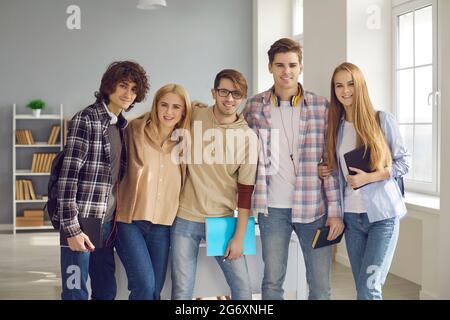 Freundliche Teenager Studentengruppe umarmt zusammen Blick auf Kamera-Porträt Stockfoto