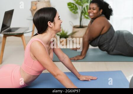 Junge Lateinerinnen machen Yoga und Pilates-Übungen zu Hause - Sport Wellness Lifestyle Konzept Stockfoto