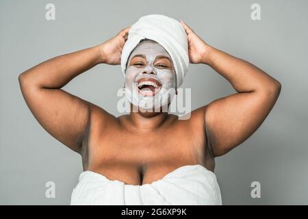 Glückliche kurvige afrikanische Frau mit Hautpflege Spa-Tag - gesunde Schönheit saubere Behandlung und Jugend Menschen Lifestyle-Konzept Stockfoto
