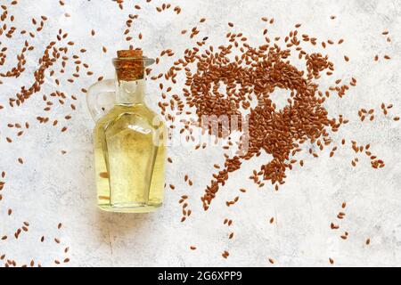 Rohe Leinsamen Öl und Samen mit einem Löffel Draufsicht auf weißem Tisch Stockfoto