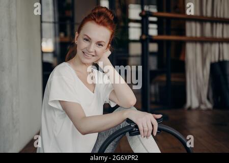 Zufriedene junge Frau in Sportbekleidung mit Pilates Ring Stockfoto