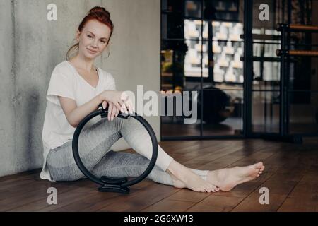 Junge sportliche Frau posiert mit Pilates Toning Ring Stockfoto