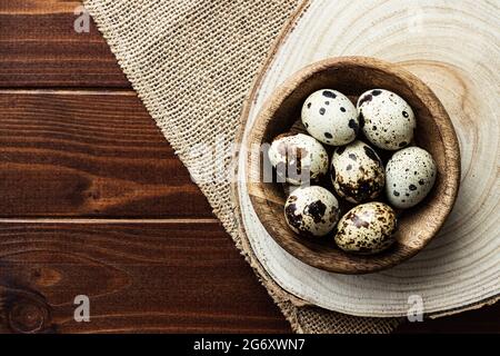 Wachteleier in Holzschüssel auf Holz; kleine gefleckte Eier; Gourmet; Delikatesse Stockfoto