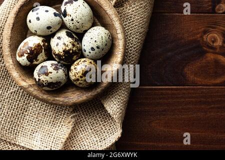 Wachteleier in Holzschüssel auf Holz; kleine gefleckte Eier; Gourmet; Delikatesse Stockfoto