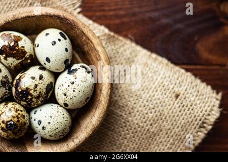 Wachteleier in Holzschüssel auf Holz; kleine gefleckte Eier; Gourmet; Delikatesse Stockfoto