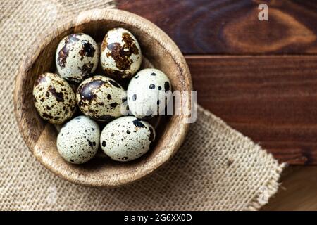 Wachteleier in Holzschüssel auf Holz; kleine gefleckte Eier; Gourmet; Delikatesse Stockfoto