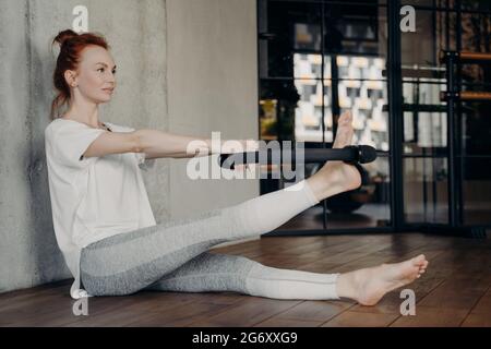 Junge attraktive rothaarige Frau mit Pilates magischen Kreis Stockfoto