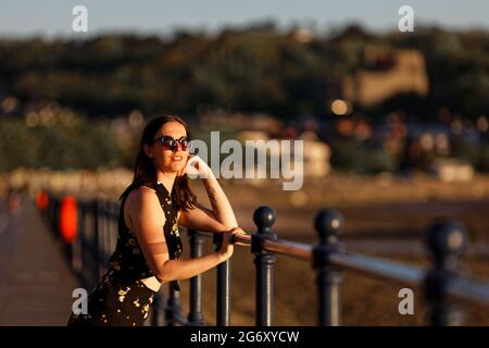 Im Bild: Natasha Jenkins macht einen Spaziergang während des Sonnenaufgangs in Mumbles Promenade, in der Nähe von Swansea, Wales, Großbritannien. Sonntag, 13. Juni 2021 Re: Hohe Temperaturen und s Stockfoto