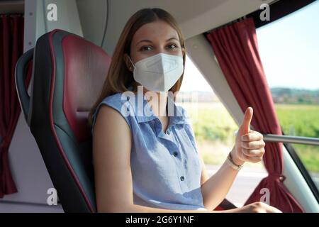 Sicher reisen. Die Frau, die im Bus lächelte, schaute auf die Kamera und zeigte den Daumen nach oben. Stockfoto