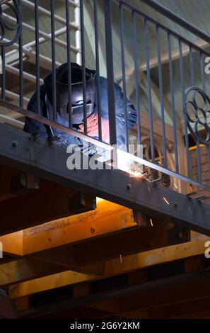 Mann bei der Arbeit schweißen die Balastrade. Stockfoto