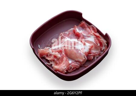 Frisches rohes Schweinefleisch auf Plastikteller auf Isolat für die Zubereitung von Speisen (einschließlich Pfad) Stockfoto