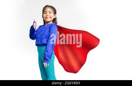 Kleine asiatische Kind spielt Superheld. Mädchen auf dem Hintergrund mit Superhelden Konzept in Girl Power Concept. Stockfoto