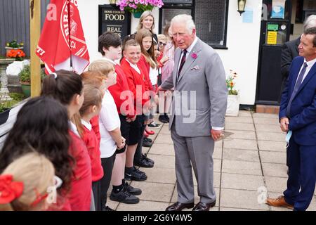 Der Prinz von Wales spricht mit Schülern der Ponthir Church in Wales Primary School während eines Besuchs im Ponthir House Inn, einem der neuesten Projekte, das mit einem Zuschuss des Community Services Fund von „Pub is the Hub“ in Ponthir, nahe Newport, Wales, eröffnet wurde. Im Rahmen einer einwöchigen Tour durch Wales während der Wales Week trifft der Prinz Mitarbeiter, Stammgäste und Mitglieder der lokalen Gemeinde, die während der Sperre von den Diensten des Pubs und dem Blockhaus-Shop profitiert haben. Bilddatum: Freitag, 9. Juli 2021. Stockfoto