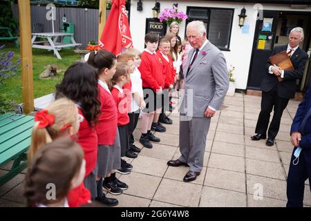 Der Prinz von Wales spricht mit Schülern der Ponthir Church in Wales Primary School während eines Besuchs im Ponthir House Inn, einem der neuesten Projekte, das mit einem Zuschuss des Community Services Fund von „Pub is the Hub“ in Ponthir, nahe Newport, Wales, eröffnet wurde. Im Rahmen einer einwöchigen Tour durch Wales während der Wales Week trifft der Prinz Mitarbeiter, Stammgäste und Mitglieder der lokalen Gemeinde, die während der Sperre von den Diensten des Pubs und dem Blockhaus-Shop profitiert haben. Bilddatum: Freitag, 9. Juli 2021. Stockfoto