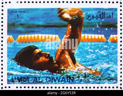 UMM AL-QUWAIN - UM 1972: Eine in der Umm al-Quwain gedruckte Briefmarke zeigt Mark Spitz, USA, Gewinner der Olympischen Sommerspiele München 1972, um 1972 Stockfoto