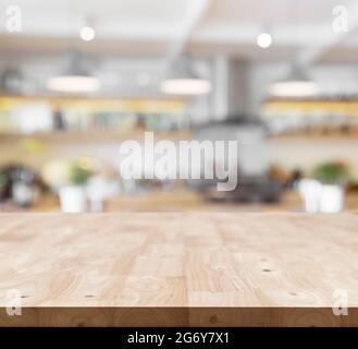 Moderner Holzbrett leerer Tisch vor verschwommenem Küchenhintergrund. Perspektivische Tischplatte zur Anzeige oder Montage Ihrer Produkte Stockfoto