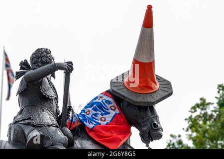 London, Großbritannien. Juli 2021. Eine Reiterstatue von Charles I. in Charing Cross, London, gesehen, nachdem England-Fans ihr ein ‘make over' mit einem Straßenkegel als Hut und einem Schal aus einer Flagge gegeben hatten. Kredit: SOPA Images Limited/Alamy Live Nachrichten Stockfoto