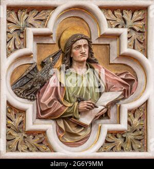 WIEN, AUSTIRA - 24. JUNI 2021: Das Relief des Evangelisten Johannes in der Kirche St. Severin von einem unbekannten Künstler Stockfoto