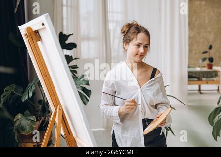 Frau mit Pinsel und Farbpalette im Studio Stockfoto
